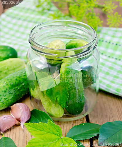 Image of Cucumbers in a jar with leaves and napkin