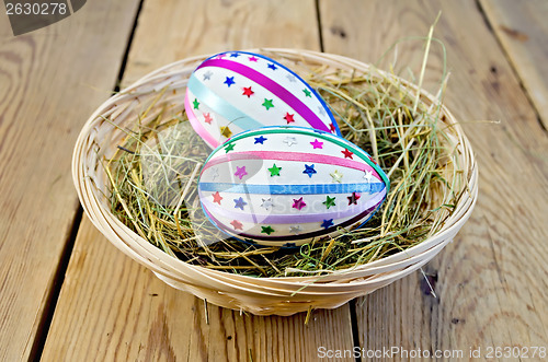 Image of Easter eggs with ribbons and sequins in a basket