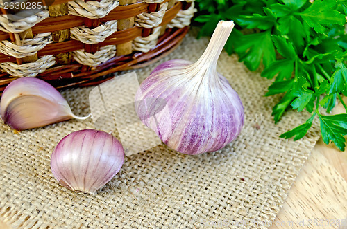 Image of Garlic with burlap and a basket on the board