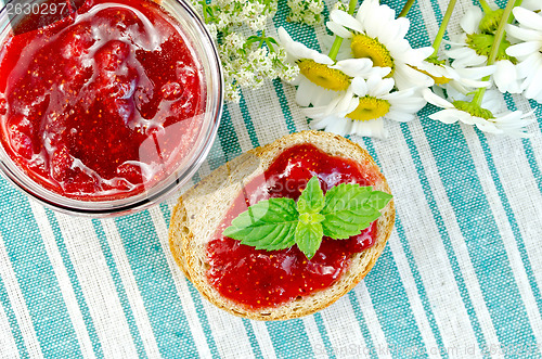 Image of Bread with strawberry jam and daisies on napkin top