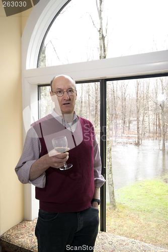 Image of man in house with flooded backyard