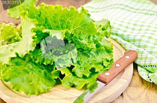 Image of Lettuce green with knife and napkin on a board