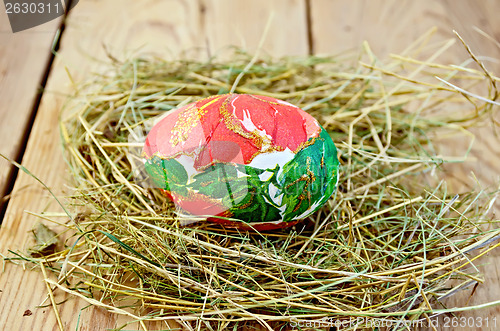 Image of Easter egg with a red flower in the hay