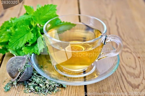 Image of Herbal tea with melissa in a cup and strainer