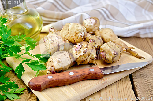 Image of Jerusalem artichoke with a knife and oil on board