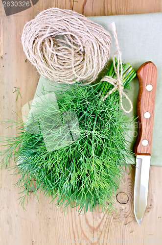 Image of Dill with a knife and twine on the board