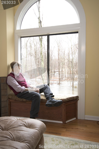 Image of man in living room looking at flood damage