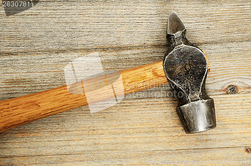Image of close-up of an old hammer on wooden background