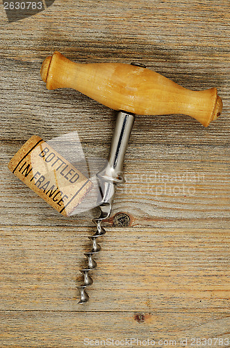 Image of vintage corkscrew and wine cork with inscription bottled in Fran