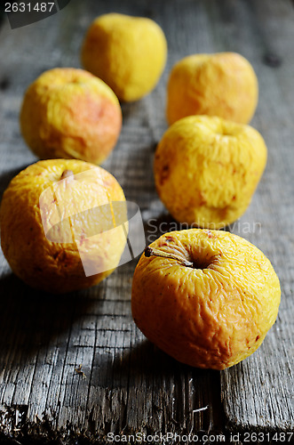 Image of wrinkled yellow apples on a wooden