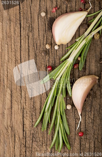 Image of garlic and rosemary on a wooden background