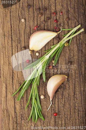 Image of garlic and rosemary on a wooden background