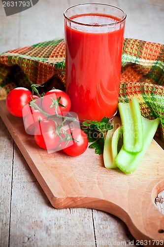Image of tomato juice in glass, fresh tomatoes and green celery