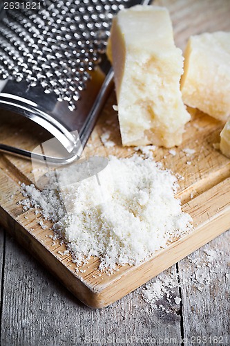 Image of grated parmesan cheese and metal grater