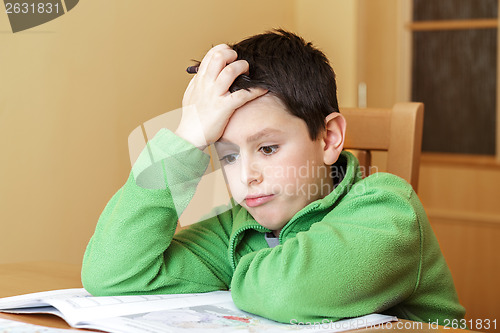 Image of bored and tired boy doing homework