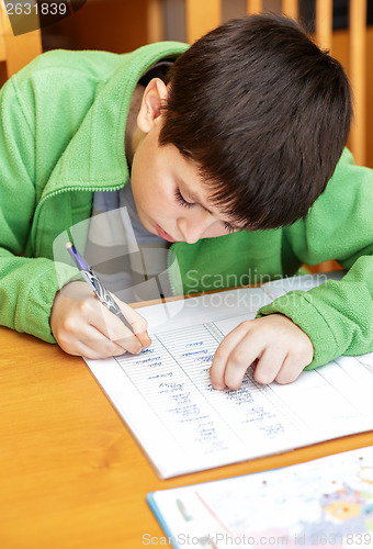 Image of bored and tired boy doing homework