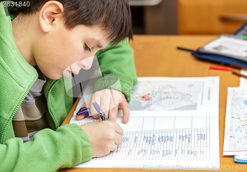 Image of bored and tired boy doing homework