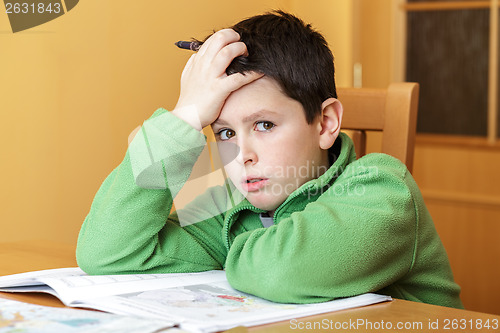 Image of bored and tired boy doing homework