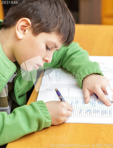 Image of bored and tired boy doing homework