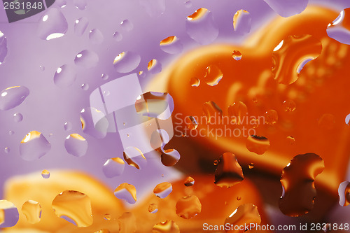 Image of Water drop with chocolate heart on violet background