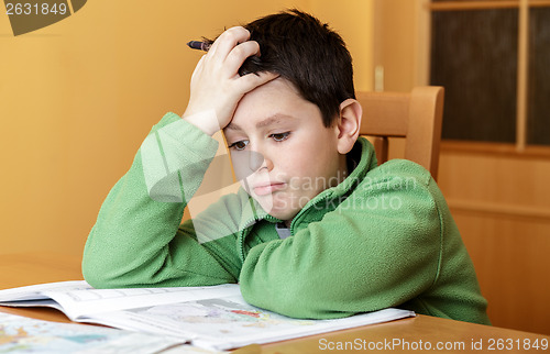 Image of bored and tired boy doing homework