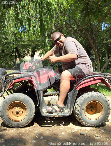 Image of fun overweight man on quad bike