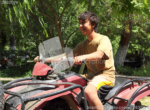 Image of happy asian boy on quad bike atv