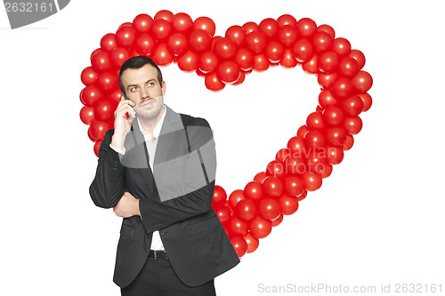 Image of Businessman talking on phone against heart shape