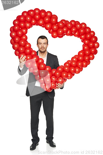 Image of Businessman holding heart shape