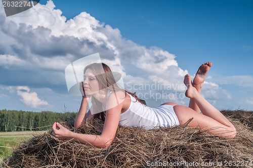 Image of Young beautiful woman on hay