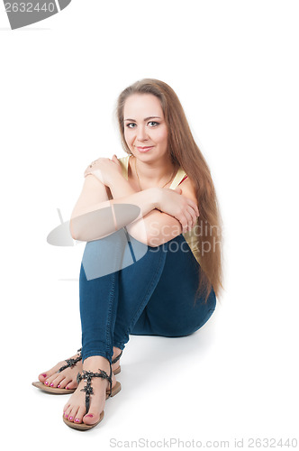 Image of Positive young female sitting on the floor