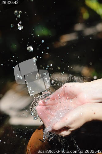 Image of splashing fresh water on woman hands