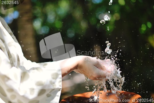 Image of splashing fresh water on woman hands