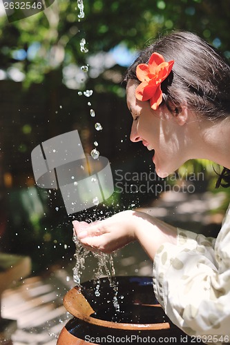 Image of splashing fresh water on woman hands