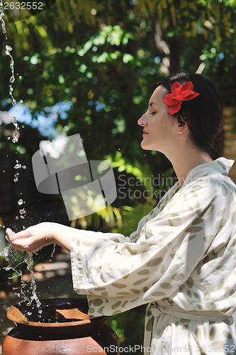 Image of splashing fresh water on woman hands