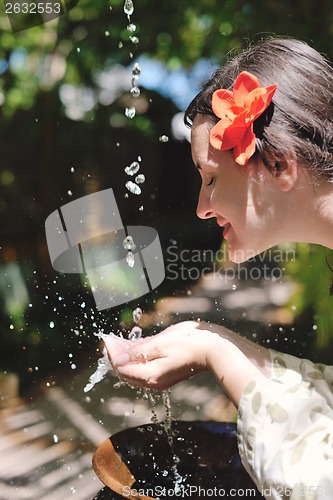 Image of splashing fresh water on woman hands
