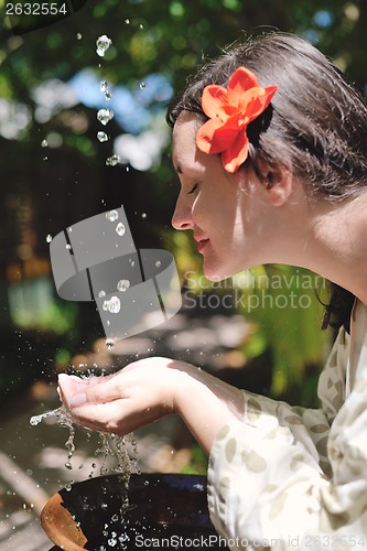 Image of splashing fresh water on woman hands