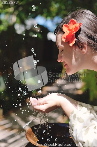 Image of splashing fresh water on woman hands