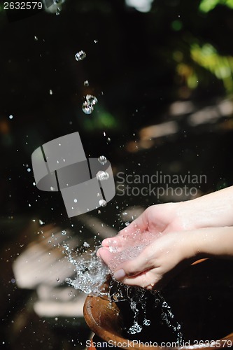 Image of splashing fresh water on woman hands