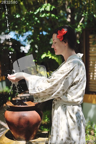 Image of splashing fresh water on woman hands