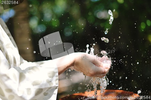 Image of splashing fresh water on woman hands