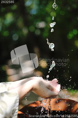 Image of splashing fresh water on woman hands