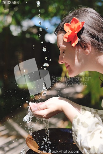 Image of splashing fresh water on woman hands