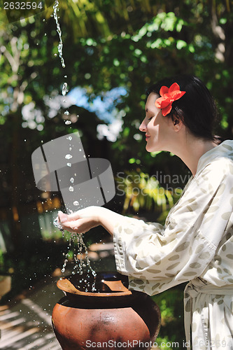 Image of splashing fresh water on woman hands