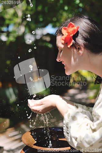 Image of splashing fresh water on woman hands