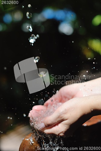 Image of splashing fresh water on woman hands