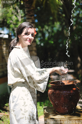 Image of splashing fresh water on woman hands