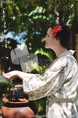 Image of splashing fresh water on woman hands