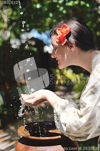 Image of splashing fresh water on woman hands