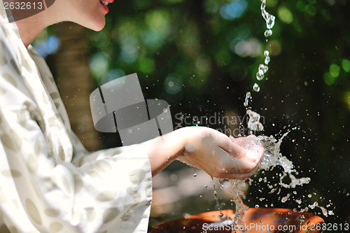 Image of splashing fresh water on woman hands